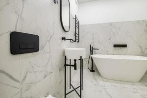 white toilet and black details of corner shower cabin with wall mount shower attachment in elite bathroom photo
