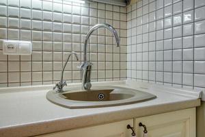 water tap sink with faucet in expensive kitchen photo