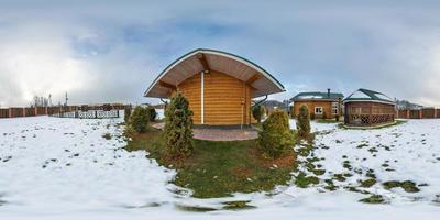 vista panorámica completa de 360 grados cerca de una pequeña casa de vacaciones de madera en el día nublado de invierno en proyección equirectangular, lista para contenido de realidad virtual vr ar foto