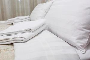 almohadas en la cama en el interior del dormitorio moderno en apartamentos tipo loft en estilo de color claro foto