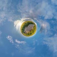 pequeño planeta diminuto. panorama esférico de 360 vistas aéreas en camino de grava entre campos de girasoles en la soleada tarde de verano. foto