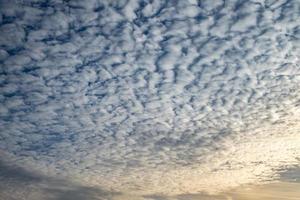 Blue sky background with tiny curly rolling clouds in the evening. Clearing day and Good windy weather photo