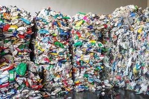 Plastic bales at the waste processing plant. Separate garbage collection. Recycling and storage of waste for further disposal. Business for sorting and processing of waste. photo