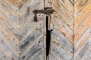 old rusty padlock on the wooden door photo