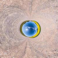 Little planet transformation of spherical panorama 360 degrees. Spherical abstract aerial view in field with awesome beautiful clouds. Curvature of space. photo