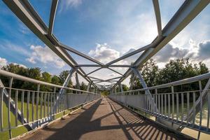 estructura de acero de hierro construcción de puente peatonal a través del río foto