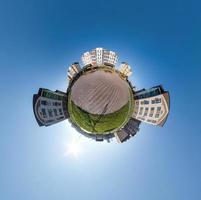 tiny planet in blue sky with clouds in city center near modern skyscrapers or office buildings. Transformation of spherical 360 panorama in abstract aerial view. photo