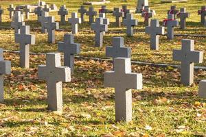 muchas cruces grises idénticas en el cementerio militar polaco otoño y puesta de sol de la vida. lucha por la congregación y la independencia de la patria foto