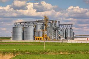 panorama view on agro silos granary elevator on agro-processing manufacturing plant for processing drying cleaning and storage of agricultural products, flour, cereals and grain. photo