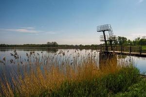 silhouette of diving tower on the lake in summer evening photo