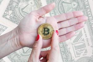 virtual money golden bitcoin women hand with red nails fingers isolated on white background photo