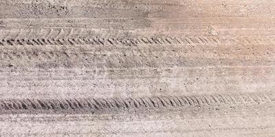 view from above on texture of gravel road with car tire tracks photo