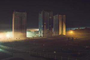 night panorama of residential area with high-rise buildings in the fog early in the morning photo