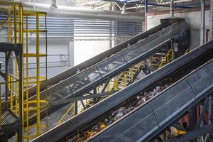 moving conveyor transporter on Modern waste recycling processing plant. Separate and sorting garbage collection. Recycling and storage of waste for further disposal. photo