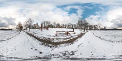 Winter full spherical seamless panorama 360 degrees angle view on road in a snowy park with blue sky near frozen city lake in equirectangular projection. VR AR content photo