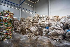 pacas prensadas de plástico en el almacén de productos terminados en la moderna planta de procesamiento de residuos peligrosos. recolección de basura por separado. reciclaje y almacenamiento de residuos para su posterior eliminación. foto