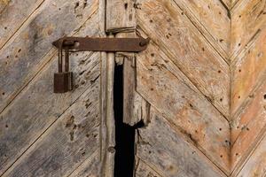 old rusty padlock on the wooden door photo