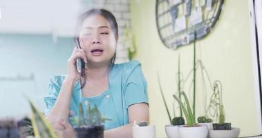 4K Asia women conversing on her smartphone at cafe. video