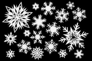 White paper snowflakes different shapes and sizes on black background. Top view. photo