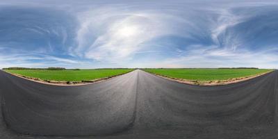 Full spherical seamless panorama 360 degrees angle view on no traffic asphalt road among fields in evening  before sunset with cloudy sky. 360 panorama in equirectangular projection, VR AR content photo