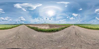 panorama esférico completo sin costuras 360 por 180 grados de ángulo de visión en la antigua carretera asfaltada entre campos en un día soleado de verano con halo en proyección equirectangular, skybox vr contenido de realidad virtual foto