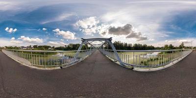 full seamless spherical panorama 360 by 180 angle view neariron steel frame construction of pedestrian bridge across the river in equirectangular projection, skybox VR virtual reality content photo