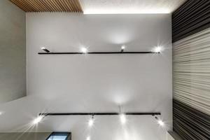 suspended or stretch ceiling with halogen spots lamps and drywall construction in empty room in apartment or house photo