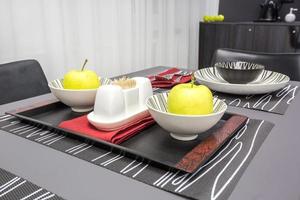 banquet table with cutlery with empty wineglasses and dishes with apples on dark style color kitchen photo