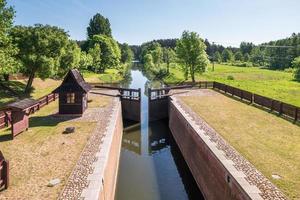 gateway lock sluice drawbridge construction on river, canal for passing vessels at different water levels photo