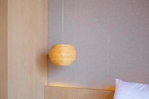 Bamboo lamp hanging in bedroom. Scandinavian, minimal and bohemian style photo