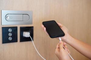 Hand Charging battery on mobile smartphone. Technology, multiple sharing and recharge concepts photo