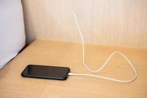 mobile smartphone charging battery on table at home or office. Technology, multiple sharing and recharge concepts photo