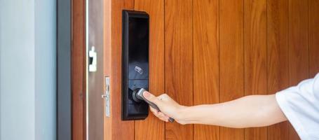 man holding handle of smart digital door lock while open or close the door. Technology, electrical and lifestyle concepts photo