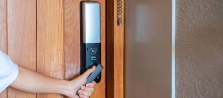 man holding handle of smart digital door lock while open or close the door. Technology, electrical and lifestyle concepts photo