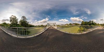 full seamless spherical panorama 360 by 180 angle view near iron steel frame construction of pedestrian bridge across the river in equirectangular projection, ready VR virtual reality content photo