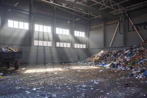 trash sorting and recycling workshop with trailer at the waste processing plant with sun rays. Separate garbage collection. Recycling and storage of waste for further disposal. photo