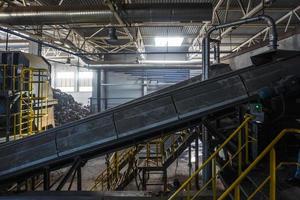 moving conveyor transporter on Modern waste recycling processing plant. Separate and sorting garbage collection. Recycling and storage of waste for further disposal. photo