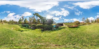 panorama esférico completo sin fisuras de 360 por 180 grados de ángulo de visión en la orilla de un pequeño río con puente en el parque de la ciudad en el día de verano en proyección equirectangular, contenido de realidad virtual ar vr foto