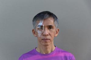 Asian adult male with right eye protective shield photo