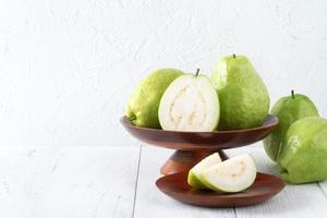 Delicious guava fruit set on white wooden table background with copy space. photo