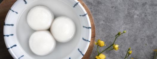 vista superior del gran tangyuan yuanxiao en un tazón sobre fondo gris para la comida del año nuevo lunar. foto