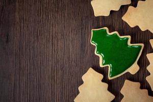 Top view of decorated Christmas tree cookie on wooden table background with copy space. photo