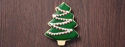 Top view of decorated Christmas tree cookie on wooden table background with copy space. photo