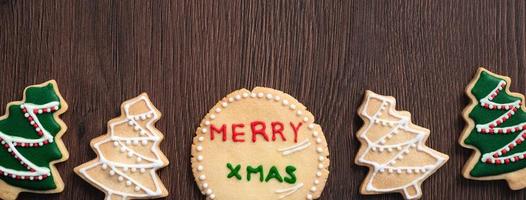 Top view of decorated Christmas tree cookie on wooden table background with copy space. photo