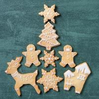 Top view of Christmas tree and snowflake cooikes with gingerbread man wearing mask. photo