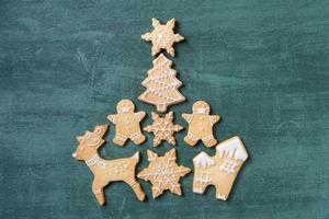 Top view of Christmas tree and snowflake cooikes with gingerbread man wearing mask. photo