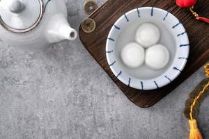 vista superior del gran tangyuan yuanxiao en un tazón sobre fondo gris para la comida del año nuevo lunar. foto