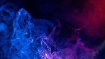 Conceptual image of colorful red and blue color smoke on dark black background. photo