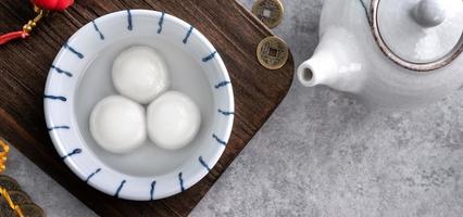 vista superior del gran tangyuan yuanxiao en un tazón sobre fondo gris para la comida del año nuevo lunar. foto