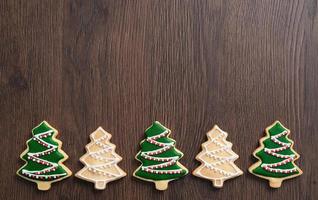 Top view of decorated Christmas tree cookie on wooden table background with copy space. photo